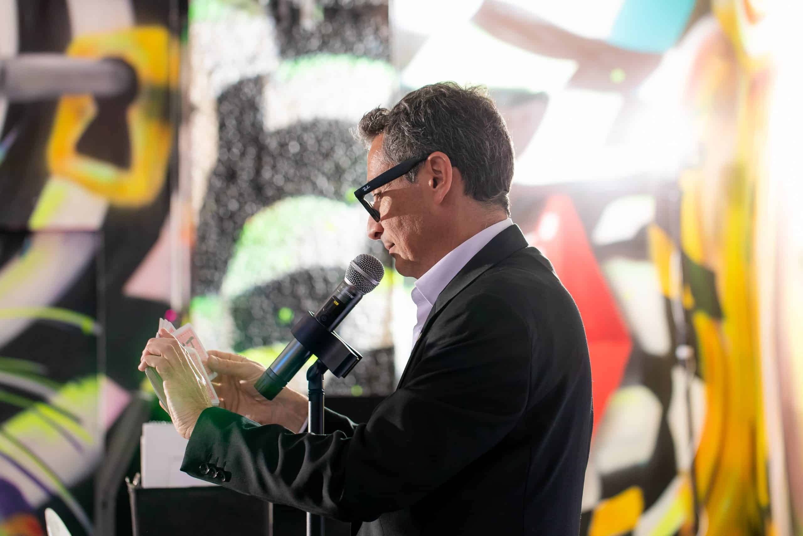 magical emcee speaking into microphone, vibrant background